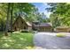 Picturesque stone home with lush landscaping, a two-car garage, a small outbuilding, and a circular driveway at 6975 Milhouse Rd, Indianapolis, IN 46221