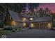 Charming stone home boasts a two-car garage, beautiful landscaping, and a welcoming entrance with an American flag at 6975 Milhouse Rd, Indianapolis, IN 46221
