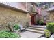 Charming front entrance with stone facade, a red door, and a cozy seating area, creating a welcoming ambiance at 6975 Milhouse Rd, Indianapolis, IN 46221