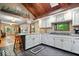 Open concept kitchen with white cabinets, granite counters, wood ceiling and flooring at 6975 Milhouse Rd, Indianapolis, IN 46221