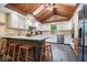 Bright kitchen featuring white cabinets, granite counters, a wood ceiling, and an island with bar stool seating at 6975 Milhouse Rd, Indianapolis, IN 46221