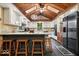 Modern kitchen with a wood ceiling, white cabinets, granite countertops, black appliances, and a breakfast bar at 6975 Milhouse Rd, Indianapolis, IN 46221