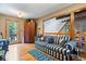 Cozy living room featuring hardwood floors, a striped sofa, and a rustic wooden staircase detail at 6975 Milhouse Rd, Indianapolis, IN 46221