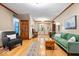 Bright living room featuring hardwood floors, neutral walls, and a cozy seating area with a green sofa at 6975 Milhouse Rd, Indianapolis, IN 46221