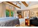 Bedroom with ensuite bathroom, wood beam ceiling, and walk-out patio with lush green views at 6975 Milhouse Rd, Indianapolis, IN 46221