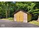 Rustic shed with double doors and unique siding, nestled among lush trees, perfect for storage or a workshop at 6975 Milhouse Rd, Indianapolis, IN 46221