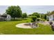 Beautifully landscaped backyard with a fire pit, seating, and a wooden fence around the perimeter at 7 Pondview Ct, Brownsburg, IN 46112