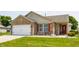 Inviting brick home with a two-car garage, red door, and lush green lawn at 7 Pondview Ct, Brownsburg, IN 46112