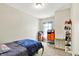 Neutral bedroom with blue bedding, carpet flooring, a window with light coming in, and a decorative gold shelving unit at 7252 Lockford N, Avon, IN 46123