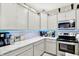 Modern kitchen features white cabinets, marble countertops and backsplash, stainless steel appliances, and LED accent lighting at 7252 Lockford N, Avon, IN 46123