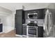 Well-lit kitchen featuring modern stainless steel appliances, sleek dark cabinets, and stylish backsplash at 750 Hillcrest Dr, Greenwood, IN 46142