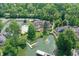 An aerial view features a spacious backyard with a pool, tennis court, and a charming pond at 8069 Middle Bay Ln, Indianapolis, IN 46236