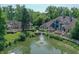 An aerial view features a pond and beautiful home, accented by green trees at 8069 Middle Bay Ln, Indianapolis, IN 46236