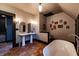Bathroom featuring brick floors, double sinks, standalone tub, and modern fixtures at 825 E Washington St, Muncie, IN 47305
