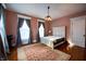 Bedroom features hardwood floors, natural light, vintage trim, and large windows at 825 E Washington St, Muncie, IN 47305