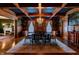 Open-concept dining room with hardwood floors, decorative rug, chandelier, and view to the living room at 825 E Washington St, Muncie, IN 47305