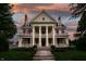 Stately home featuring grand columns, intricate details, and a beautifully landscaped front yard at 825 E Washington St, Muncie, IN 47305