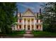 Stunning exterior elevation of home featuring red accents, columns, and well-manicured lawn at 825 E Washington St, Muncie, IN 47305