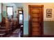 Hallway with wooden stairs and a door at 825 E Washington St, Muncie, IN 47305