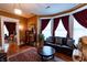 Inviting living room featuring a comfortable leather sofa, a decorative rug and beautiful bay window views at 825 E Washington St, Muncie, IN 47305