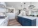Open-concept kitchen featuring modern appliances, quartz countertops, an island with seating, and hardwood floors at 8356 Leander Ave, Zionsville, IN 46077