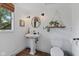 Cozy bathroom with modern fixtures, pedestal sink, stylish mirror, and a window for natural light at 8435 Hilltop Ln, Martinsville, IN 46151