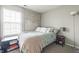 Comfortable bedroom featuring soft green bedding, window for natural light, and neutral decor at 8526 Country Meadows Dr, Indianapolis, IN 46234