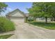 Single-Gathering home with two-car garage, brick accents, manicured lawn and long driveway leading up to the house at 8526 Country Meadows Dr, Indianapolis, IN 46234