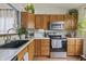 Well-lit kitchen with stainless steel appliances, wood cabinets, and a view of the backyard at 8526 Country Meadows Dr, Indianapolis, IN 46234