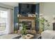 Living area boasts a brick fireplace, sliding glass door, and a mounted television at 8526 Country Meadows Dr, Indianapolis, IN 46234