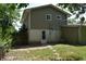 Back of house shows the yard with sparse grass and a door for access to the basement at 9016 Neptune Dr, Indianapolis, IN 46229
