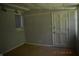 This bedroom features neutral paint, a window with blinds, and a plain door at 9016 Neptune Dr, Indianapolis, IN 46229