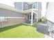 Backyard featuring a covered patio, artificial turf, gray siding and a brick foundation at 9248 Hawley Dr, Indianapolis, IN 46216