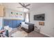Cozy bedroom with a twin bed, blue wainscoting, TV, ceiling fan, and decorative accents at 9248 Hawley Dr, Indianapolis, IN 46216