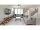 Spacious living room featuring modern sofas, decorative rug, and staircase with wood railing at 9248 Hawley Dr, Indianapolis, IN 46216