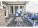 Relaxing covered patio with stylish outdoor seating, rug, and brick pillars at 9248 Hawley Dr, Indianapolis, IN 46216