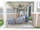 Cozy covered patio with brick accents, ceiling fan, and stylish blue furniture at 9248 Hawley Dr, Indianapolis, IN 46216