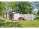 Fenced backyard showcasing a storage shed, neatly stacked firewood, and green lawn at 9256 Colgate St, Indianapolis, IN 46268