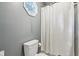 Bathroom with white shower curtain, toilet, and window with an octagon design, providing natural light at 9256 Colgate St, Indianapolis, IN 46268