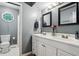 Well-lit bathroom featuring double vanity, framed mirrors, and separate toilet with shower area at 9256 Colgate St, Indianapolis, IN 46268