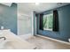 Bright bathroom featuring a white vanity, tub/shower with glass door, and a window letting in natural light at 9256 Colgate St, Indianapolis, IN 46268