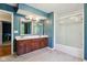 A bathroom with double vanity, wood cabinets, large mirror, and tub/shower combination at 9256 Colgate St, Indianapolis, IN 46268