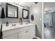 Well-lit bathroom featuring double vanity, framed mirrors, and en-suite access to bedroom at 9256 Colgate St, Indianapolis, IN 46268