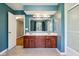 A bathroom with double vanity, wood cabinets, large mirror, and tub/shower combination at 9256 Colgate St, Indianapolis, IN 46268