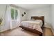 Bedroom with cozy brown carpet, natural light from the window, and neutral striped bedspread at 9256 Colgate St, Indianapolis, IN 46268
