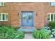 Inviting brick entryway with double blue doors, decorative plants, and stylish outdoor lighting at 9256 Colgate St, Indianapolis, IN 46268