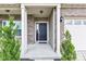 A welcoming front porch with a dark front door, flanked by green shrubs and brick columns at 937 Maple Stone Dr, Greenwood, IN 46143