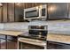 Stylish kitchen featuring stainless steel appliances, dark cabinetry, and a modern backsplash at 937 Maple Stone Dr, Greenwood, IN 46143