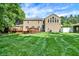 Expansive backyard featuring a well-maintained lawn, inviting deck, and the house with lots of windows for natural light at 9650 Copley Dr, Carmel, IN 46290