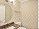 Well-appointed half bathroom features a granite countertop, decorative wallpaper and modern fixtures at 9650 Copley Dr, Carmel, IN 46290